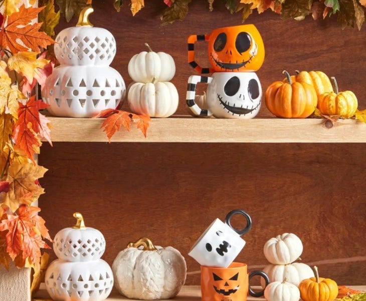 Wooden shelves holding Halloween decorations including pumpkin mugs and ceramics