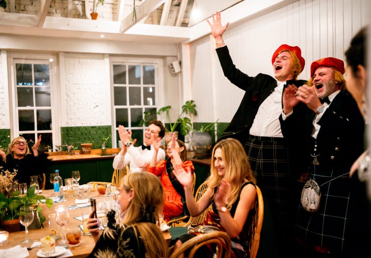 People laughing and clapping at a Burns Night party