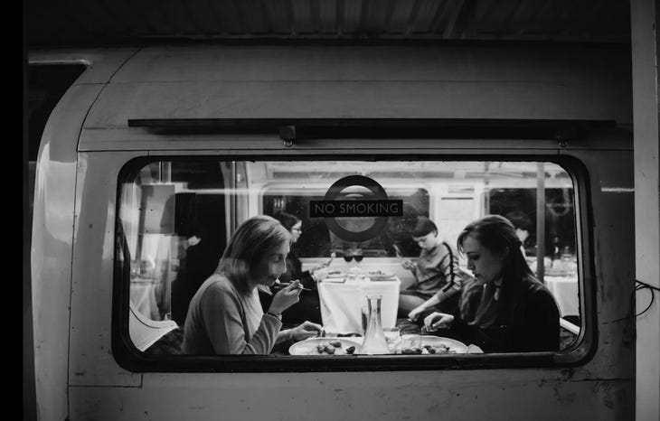 People dining in a tube carriage