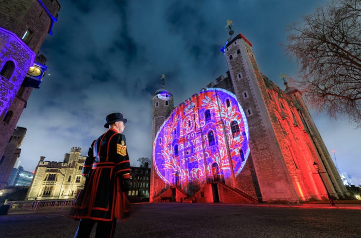 A Beefeater looking at illuminations on the Tower of London