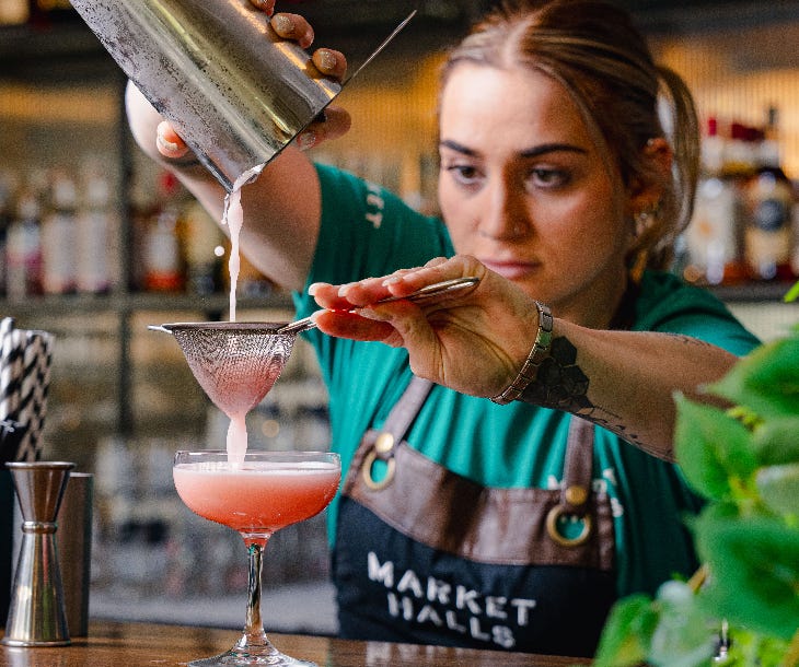 A bartender at Market Halls creating a cocktail