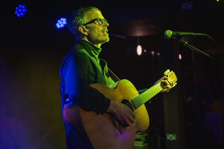 A man playing a guitar on stage.