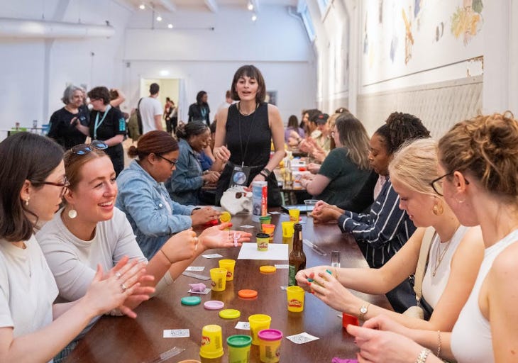 Adults sitting around a table taking part in a workshop involving Play Doh