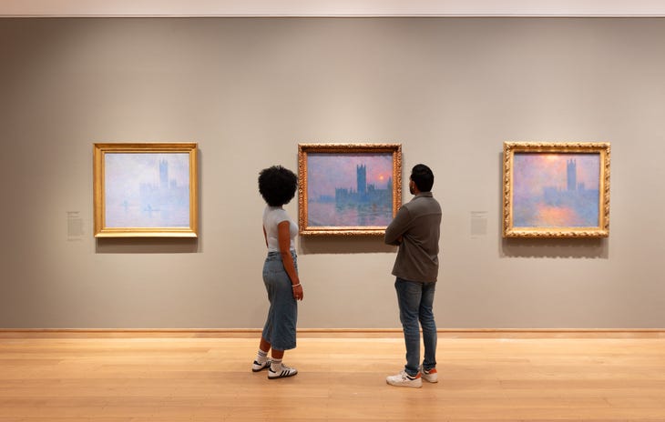 Some people gazing at an impressionist painting in a gallery