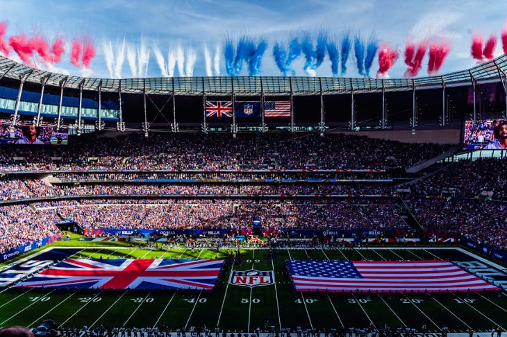 A packed sports stadium with UK and USA flags