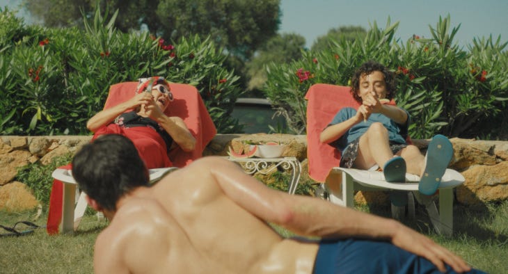 A still from a film showing people sunbathing outside