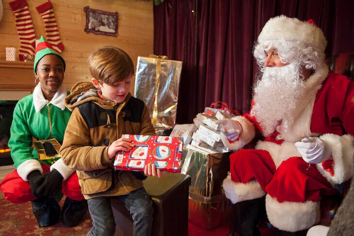 A kid receiving a present from Santa