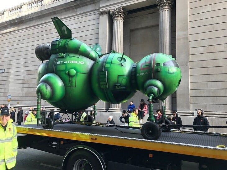 A green bug shaped craft on the back of a float