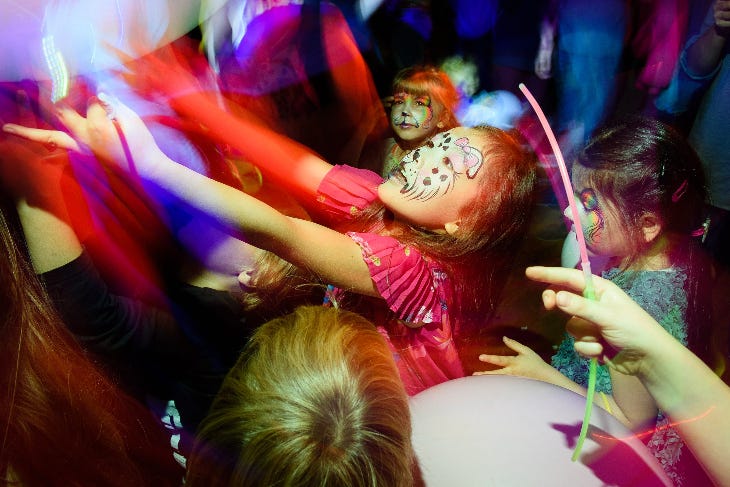 Children with face paint on a dancefloor