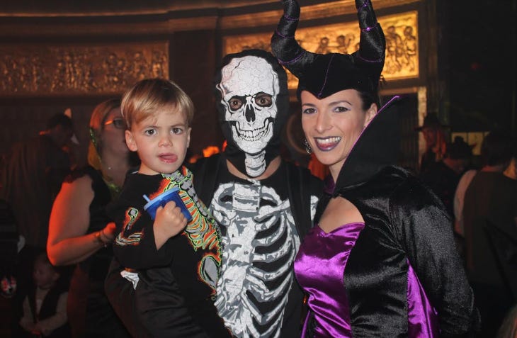 Parents and a young boy dressed up in Halloween costumes 