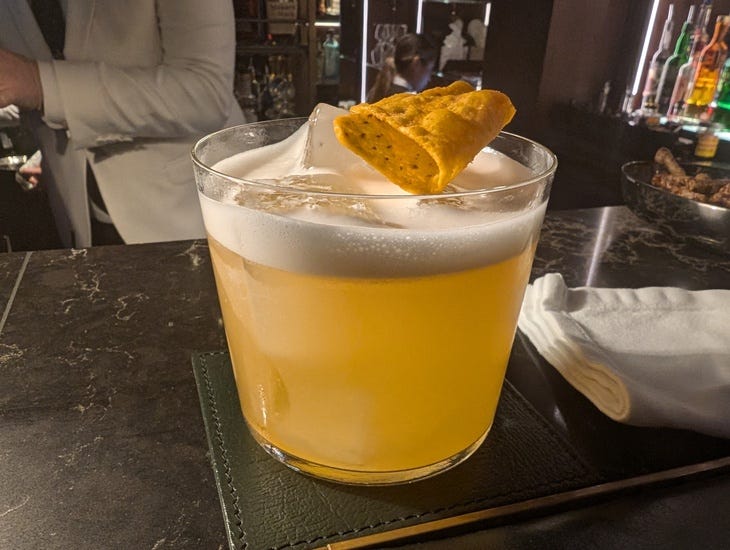 A cocktail with a Dorito perched on top