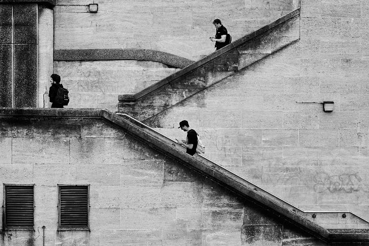 A black and white photo of people walking up and down stairs