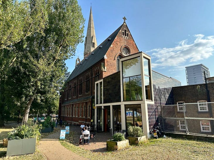 The exterior of a red brick church building, with a modern-looking extension