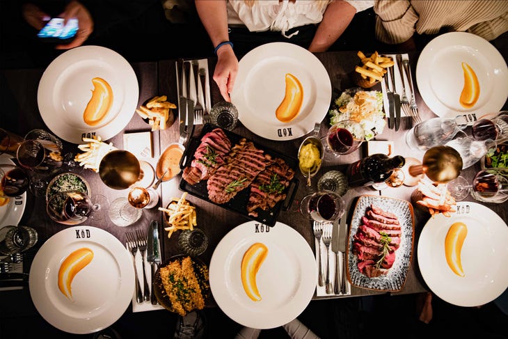 A spread of steak and plates awaiting to be dished up