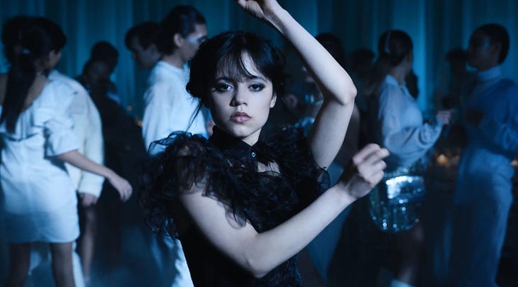 A still from Netflix series Wednesday, with Jenna Ortega dressed in a black dress and dancing, in the role of Wednesday Addams