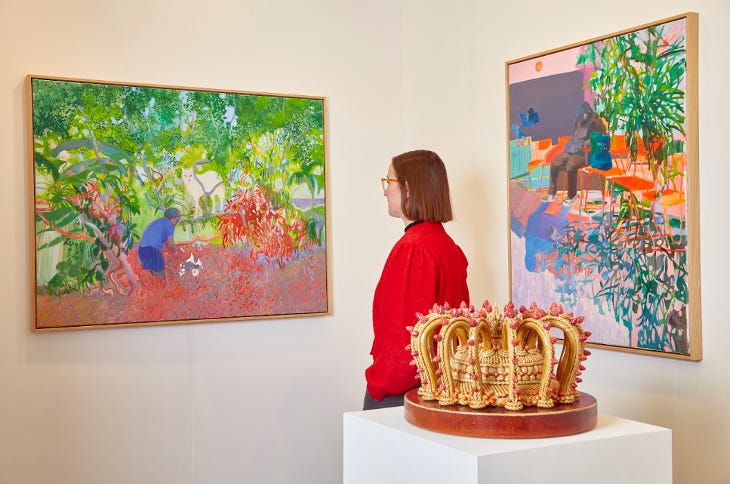 A woman admiring a painting at London Art Fair