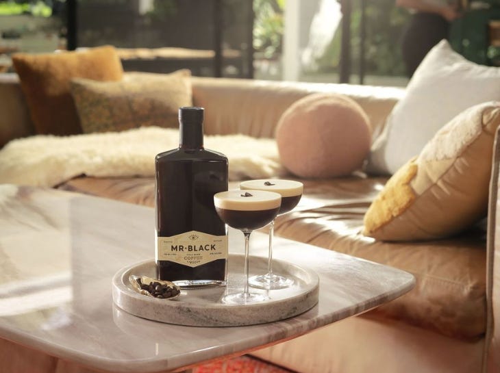 Two espresso martinis on a tray on a table