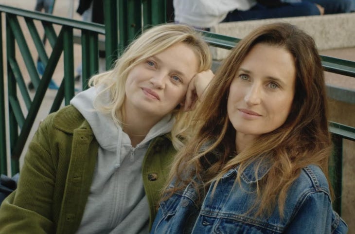 A still from the film Three Friends showing two women sitting next to each other on a bench