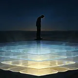 A small silhouetted figure stands at the center of a stack of large glowing transparent platform layers extending…