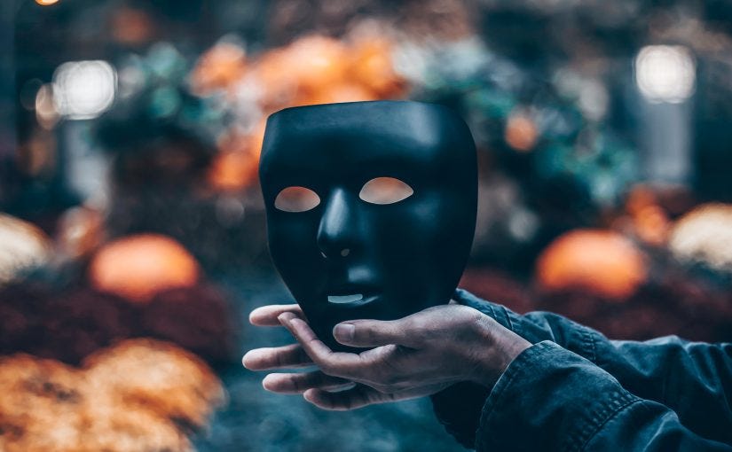 Hands holding a black porcelain mask.