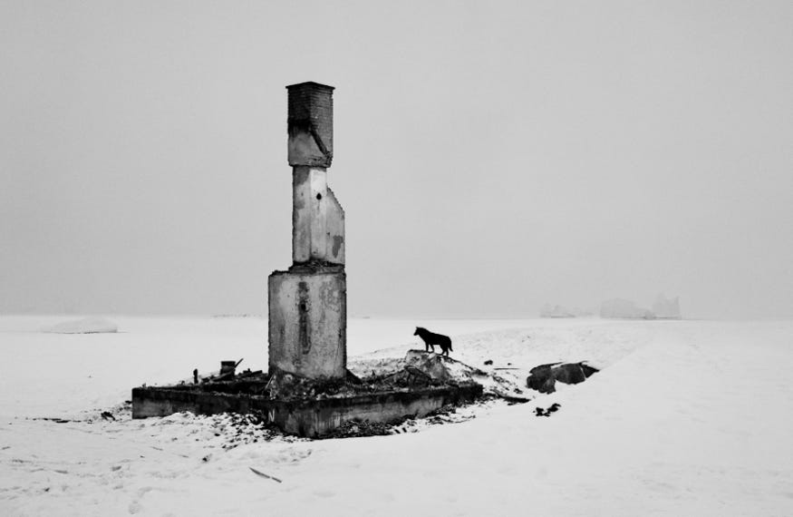 A black and white photograph of an abandoned structure in the Arctic