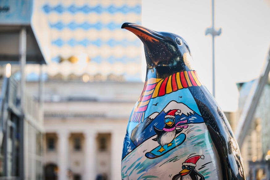 A sculpture of a penguin painted with a ski scene