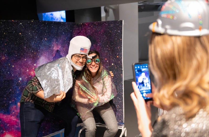 A couple posing for a photo, wearing space-themed fancy dress items