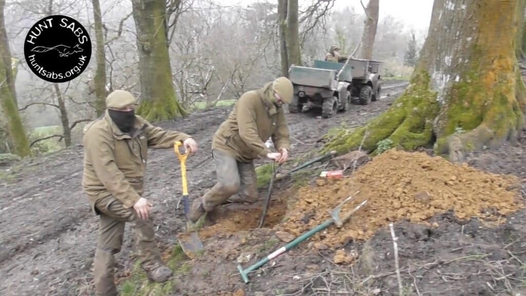 Axe Vale Harriers masked terriermen dig into a badger sett. Image Hunt Saboteurs Association