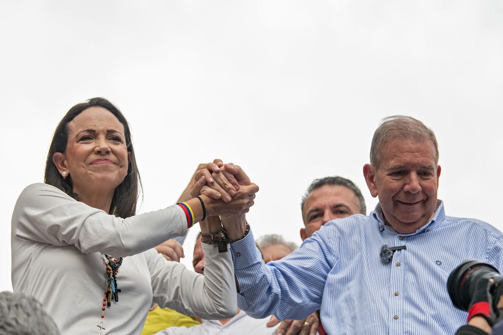 Opposition leader María Corina Machado and opposition presidential candidate Edmundo González join hands at a rally protesting the Venezuela presidential election results.