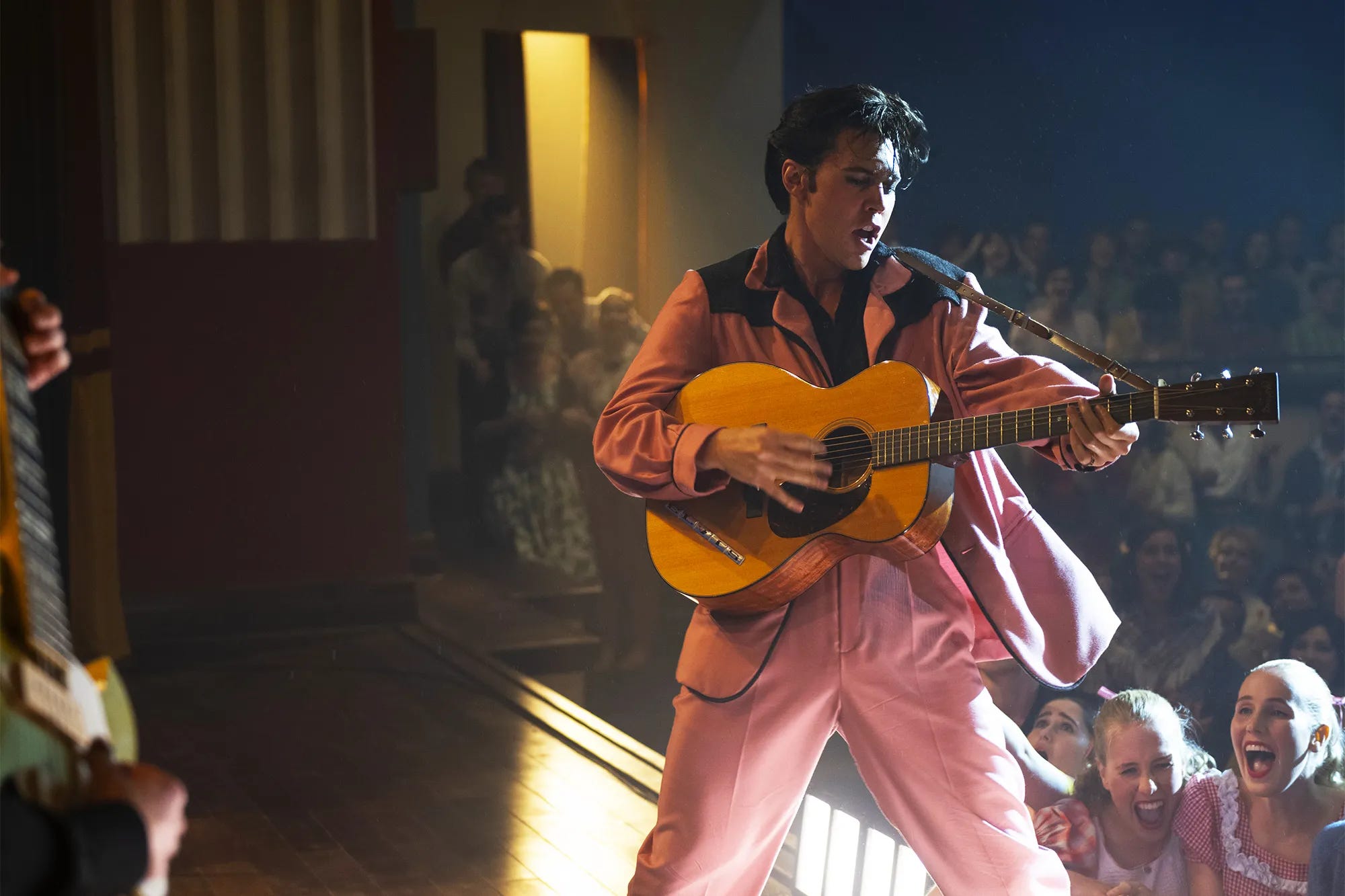 Austin Butler performs performs as Elvis Presley in a pink satin suit.