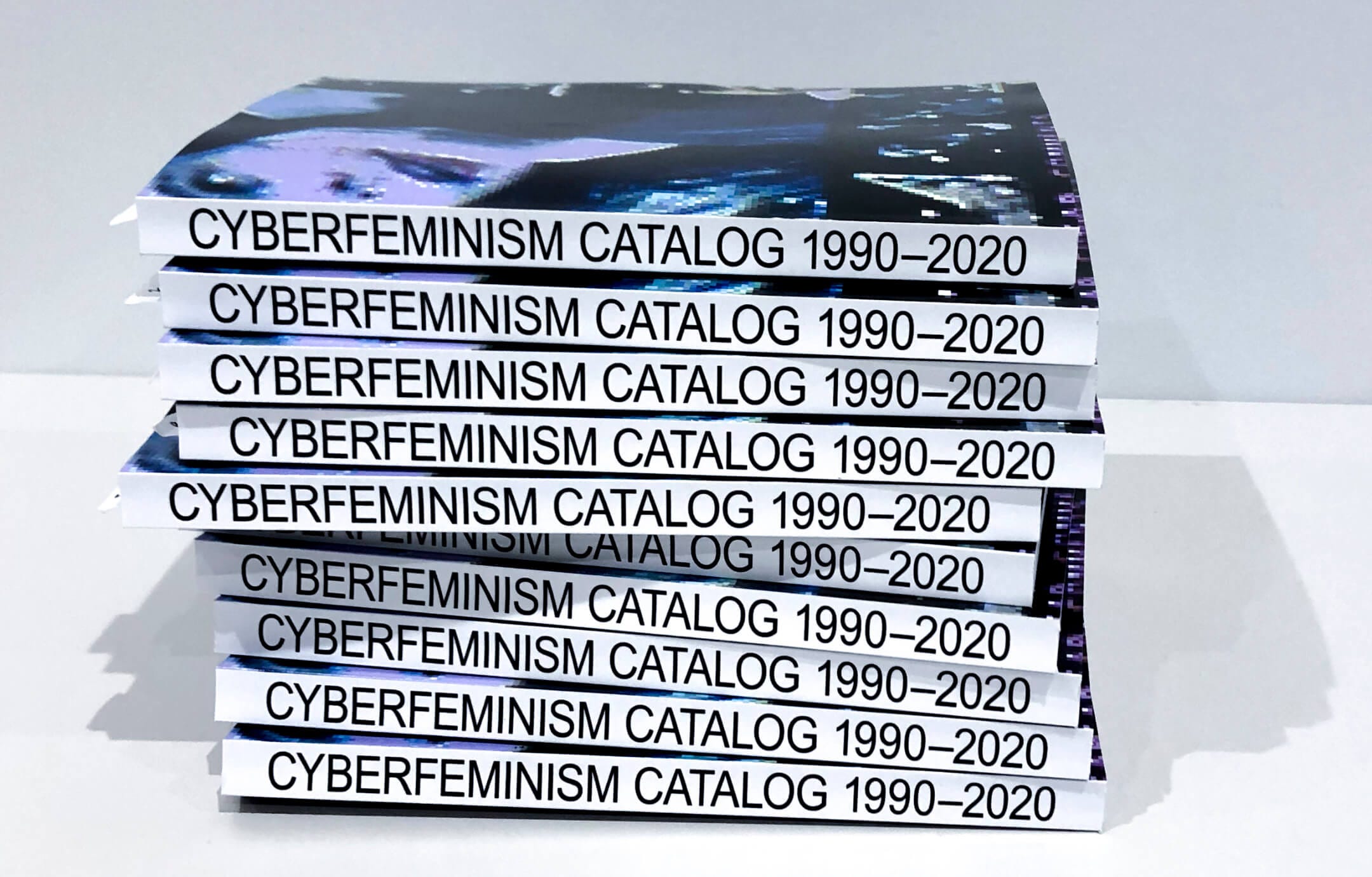 Stacked copies of Mindy Seu's Cyberfeminism Catalog, 1990–2020