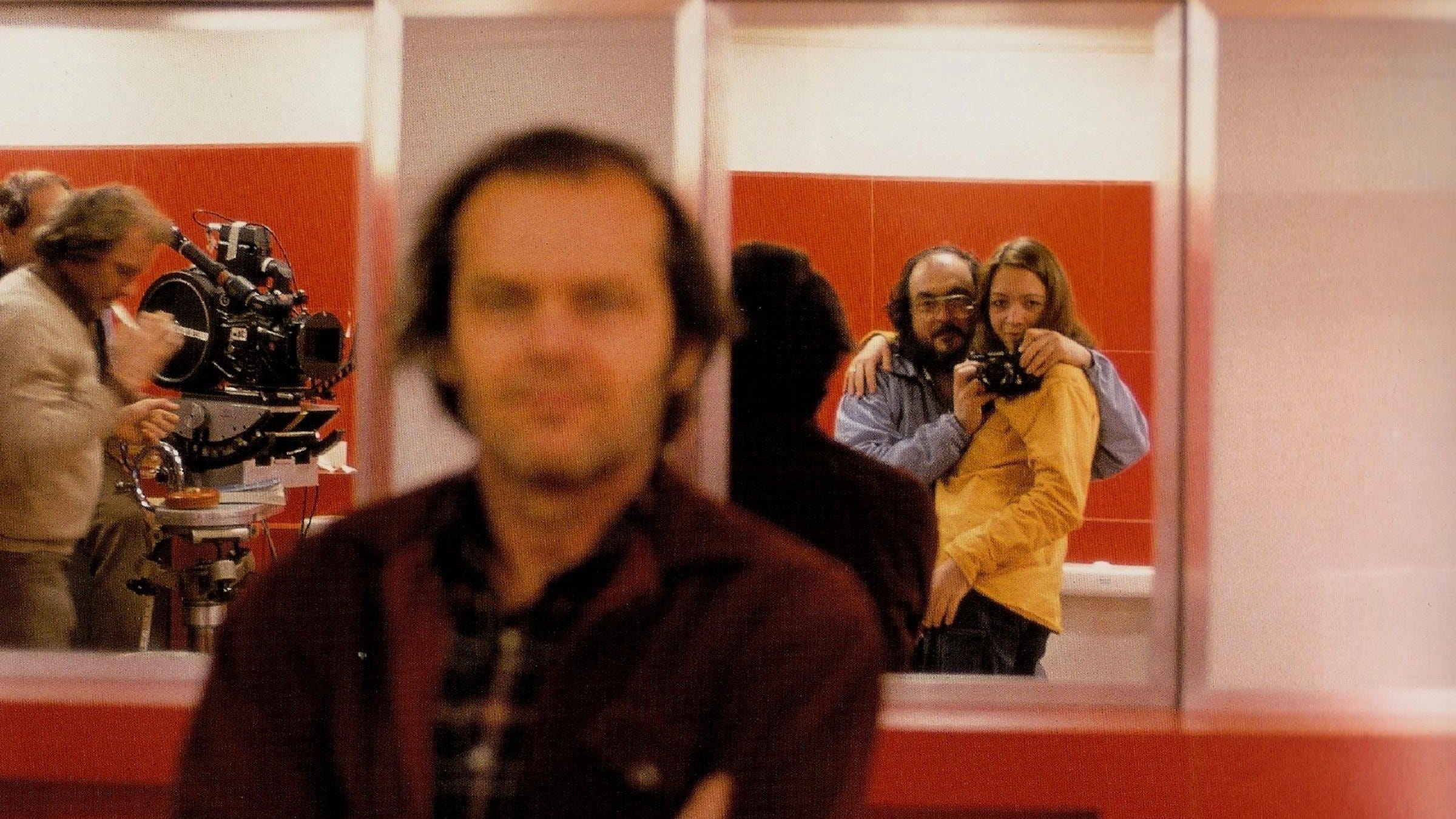 Director Stanley Kubrick takes a self portrait of himeself in a mirror, with Jack Nicholson obscured closer to camera, on the set of "The Shining"
