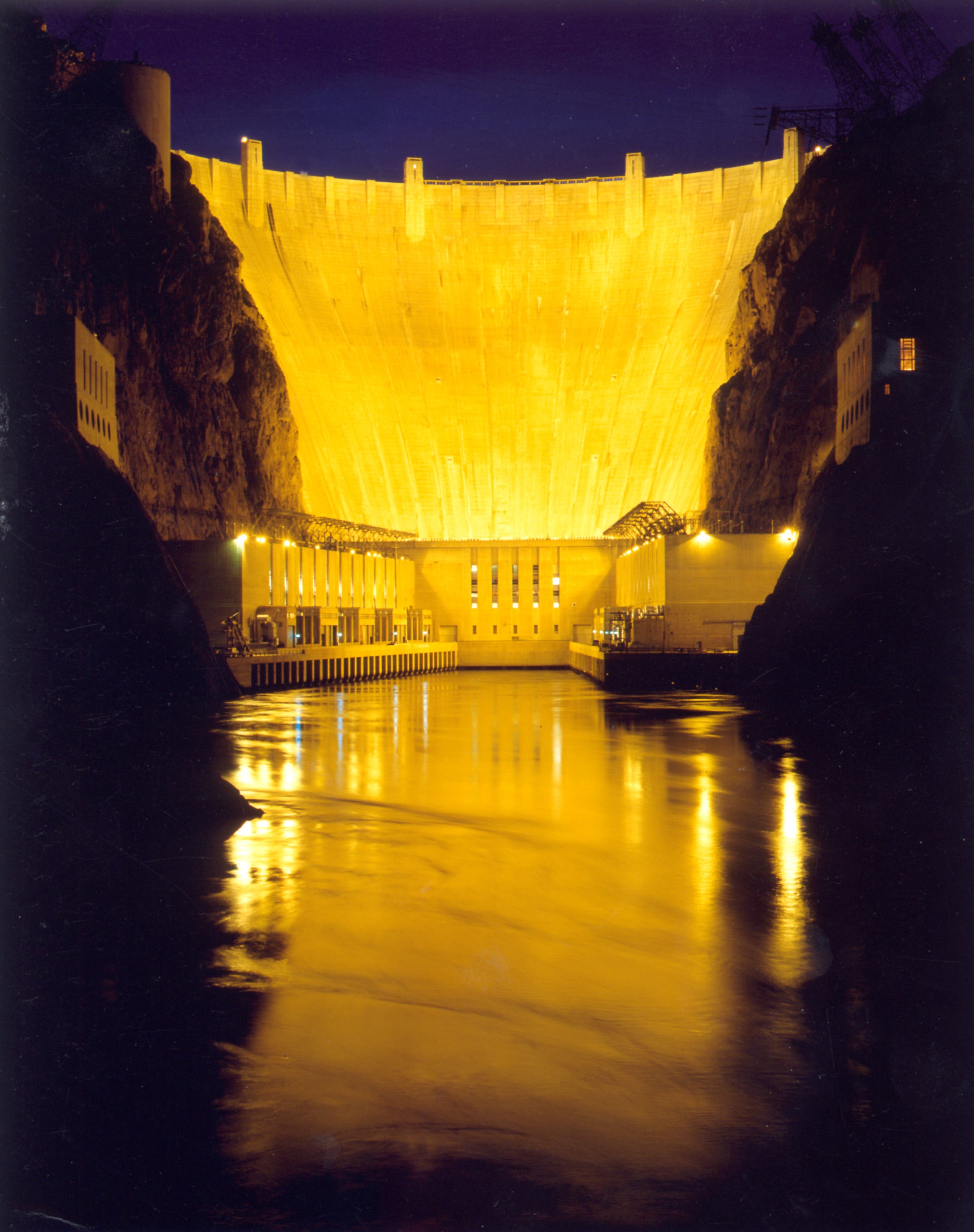 The Hoover Dam, illuminated at night in breathtaking brilliant incandescent splendor