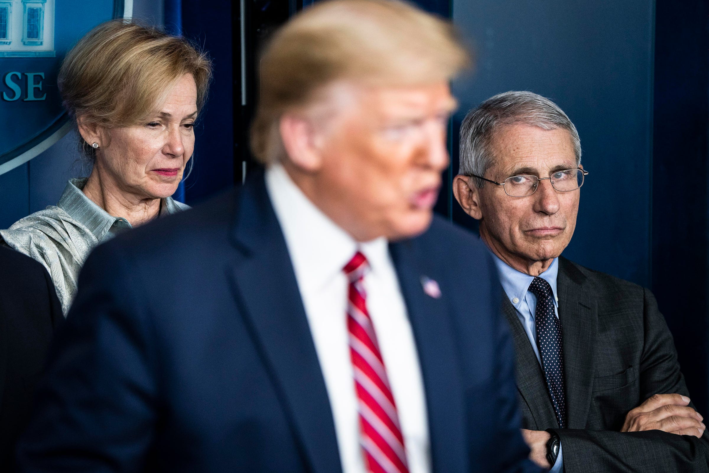 From left in background, Dr. Deborah Birx and Dr. Anthony Fauci listen as President Donald Trump speaks at a coronavirus briefing in Washington, DC, on March 20.
