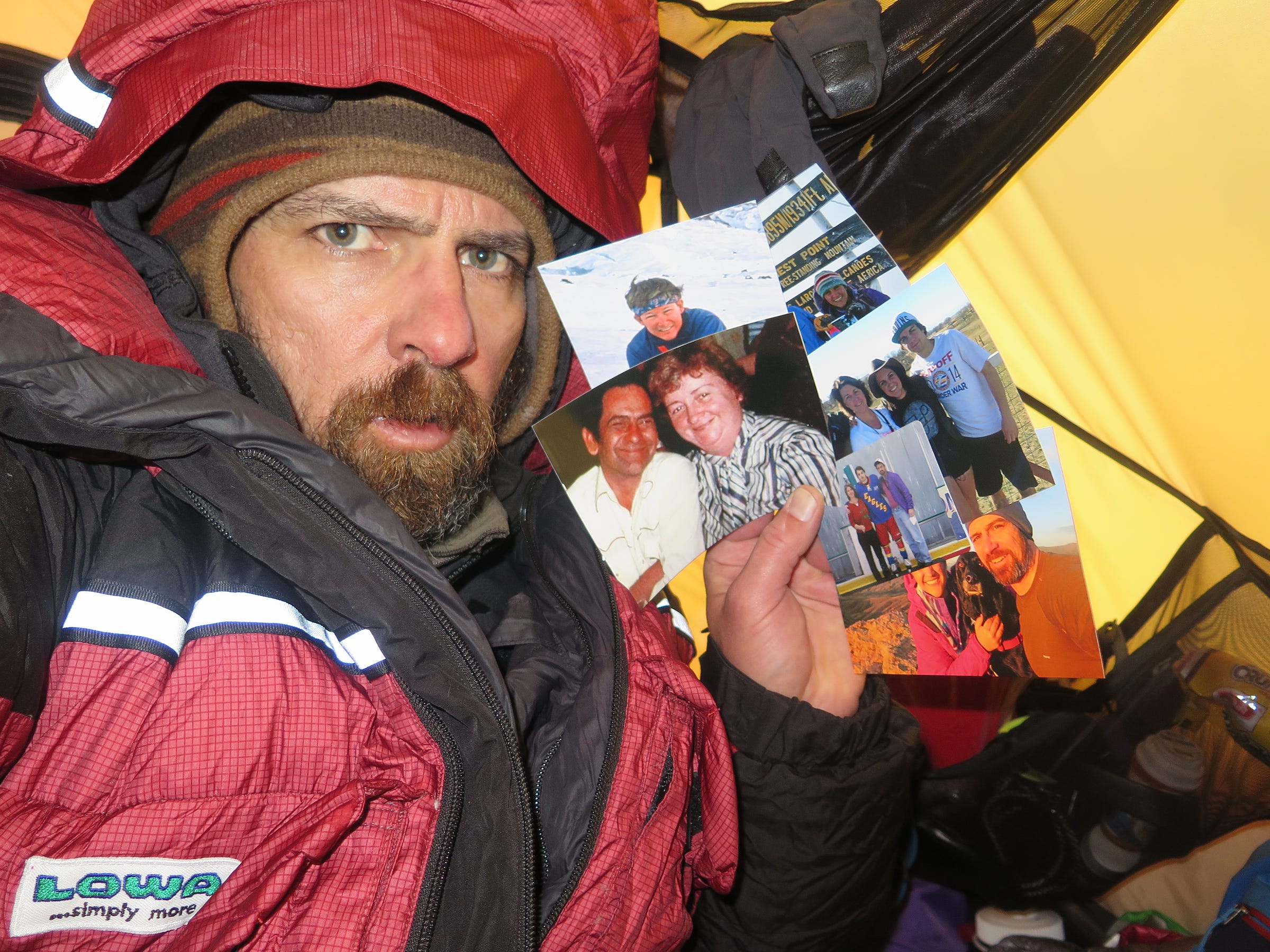 Jim Davidson holding aloft pictures of his family soon after experiencing the 7.8-magnitude earthquake and avalanches at Camp One (19,700 feet) on Everest.