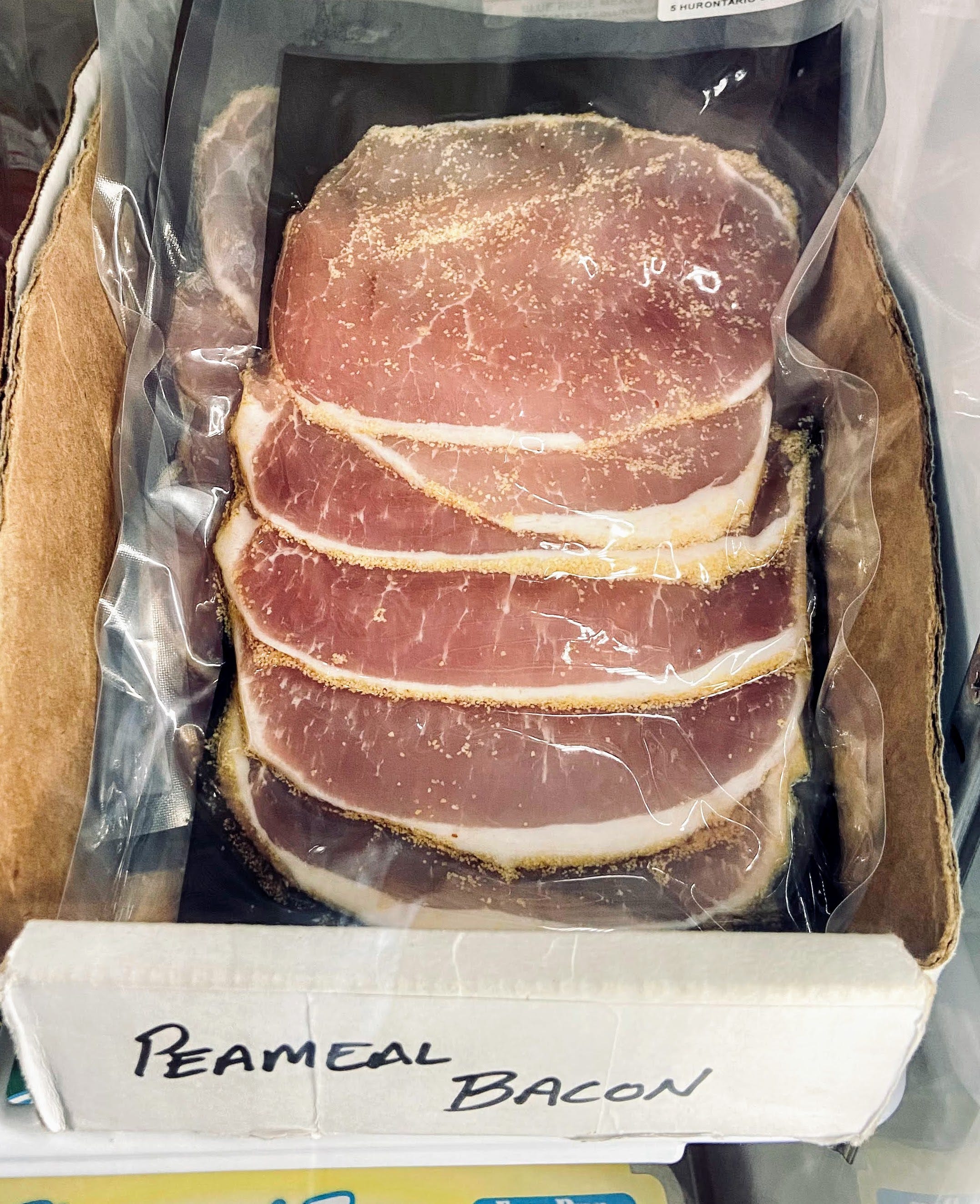 sealed package of peameal bacon in fridge