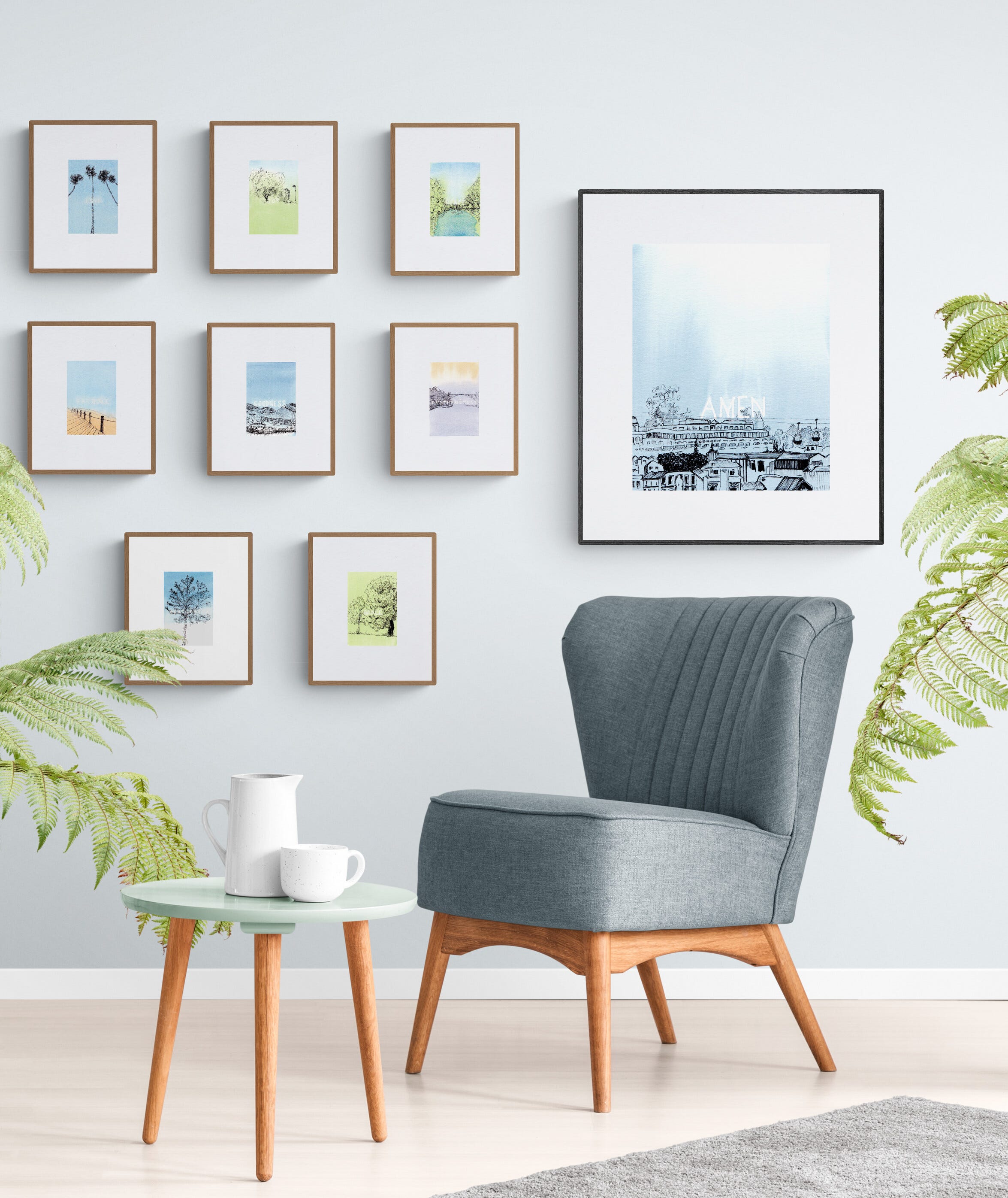Image: nine framed line drawing with watercolour artwork from Meditations in words collection, in a corner of a sitting room setting, with a muted blue armchair, pastel green side table, and leafy plants.