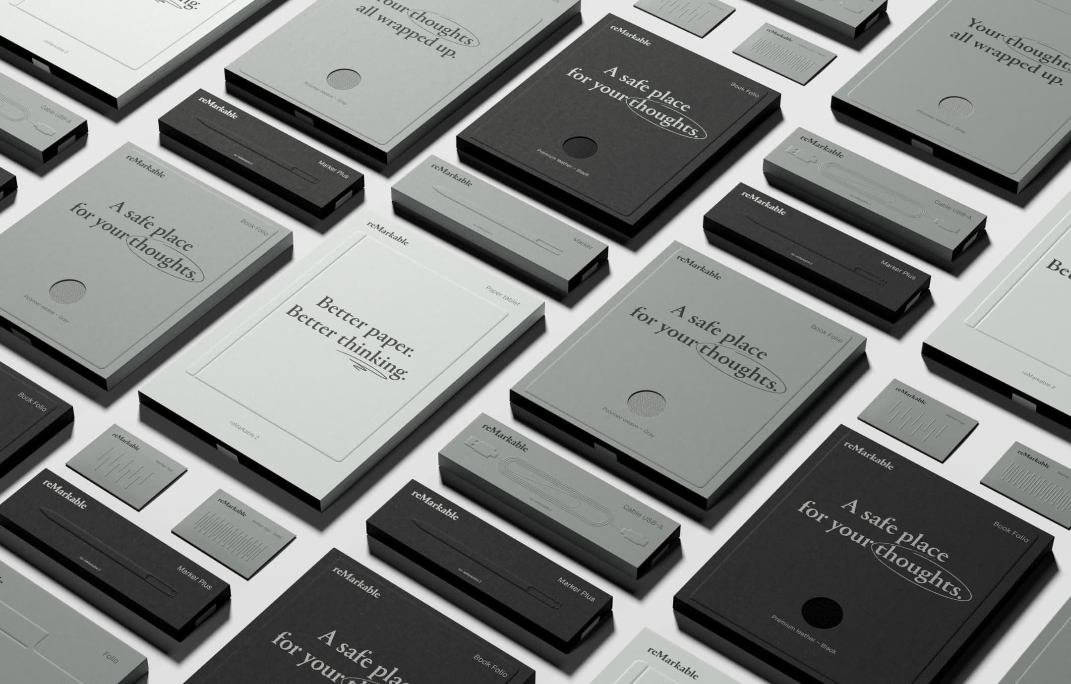 Photo depicting the full range of reMarkable packaging in shades of gray. These minimal rectangular packages feature embossed highlights and black text.