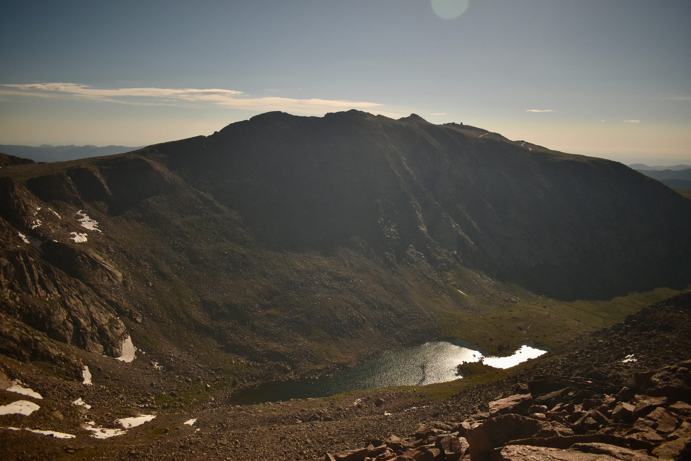 a look across a mountain ridge at another peak. A lake stands between.