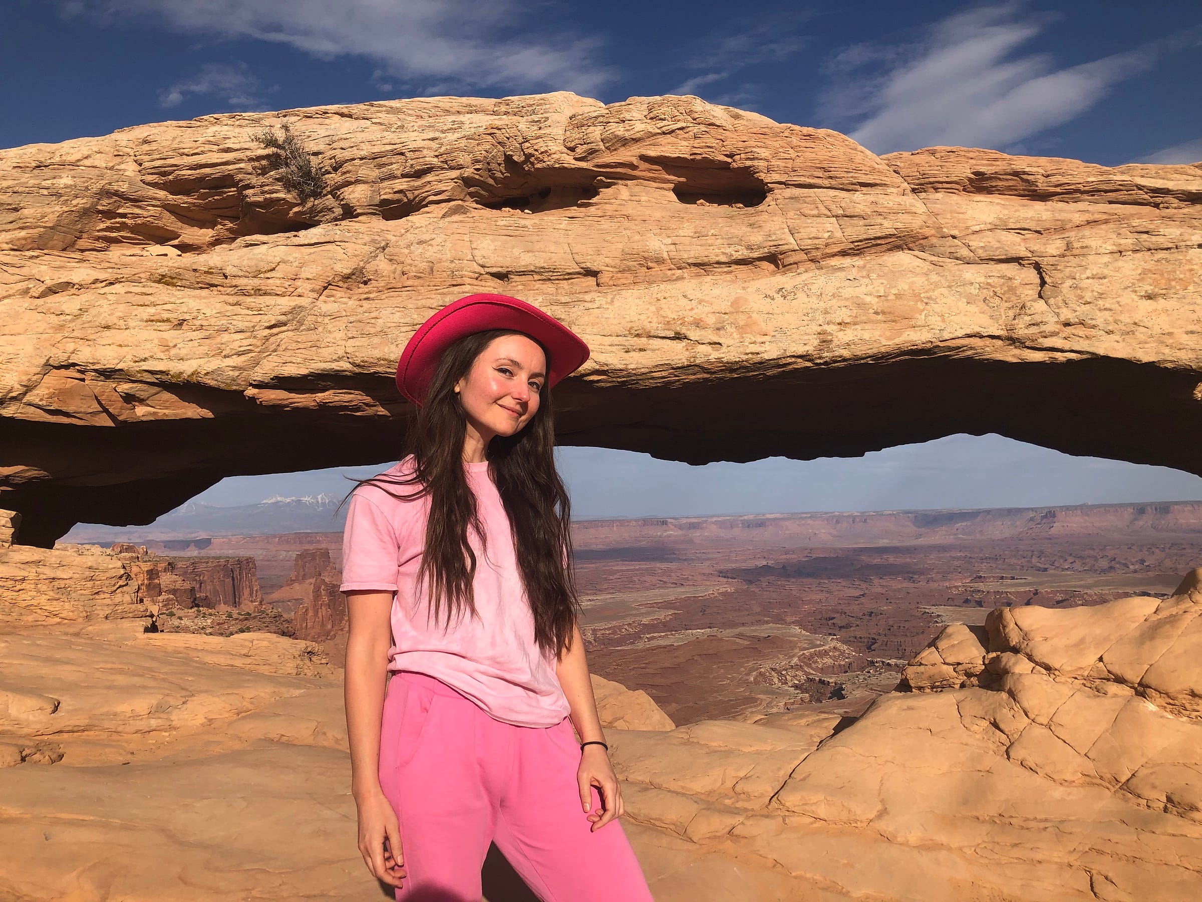 Mary Boo Anderson stands in all pink, including a pink cowboy hat, in front of a large rock structure.