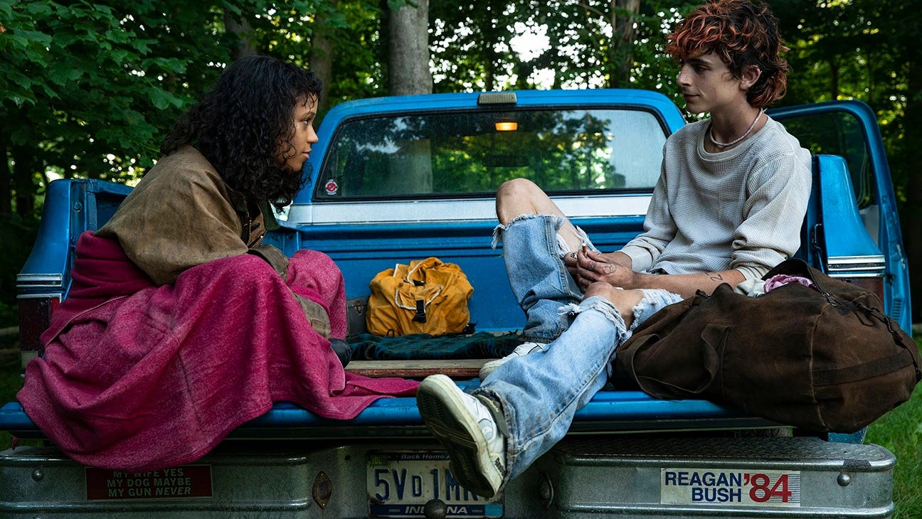 Maren (Taylor Russell) and Lee (Timothee Chalamet) sitting in the back of a truck talking