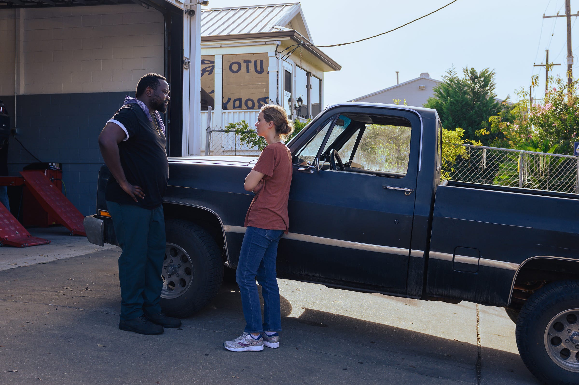 Actors Brian Tyree Henry and Jennifer Lawrence, outside of a car mehanic shop, during the day, in the feature film "Causeway."