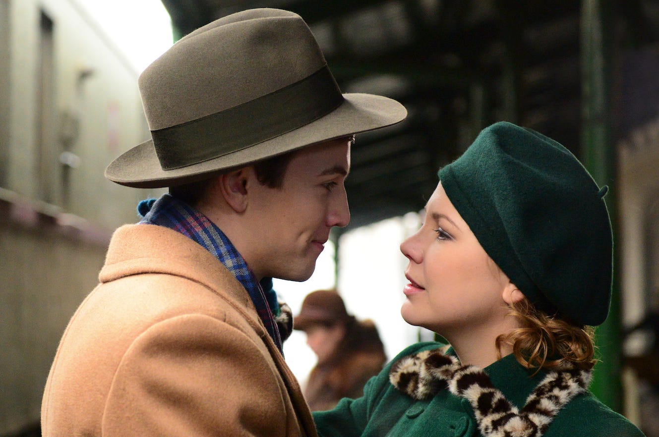 Actors Leo Suter and Adelaide Clemens look at each other closely, in a train station, in an official image from the film "I'll Find You."