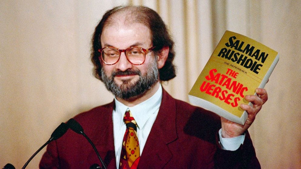 Author Salman Rushdie holding a copy of his book The Satanic Verses