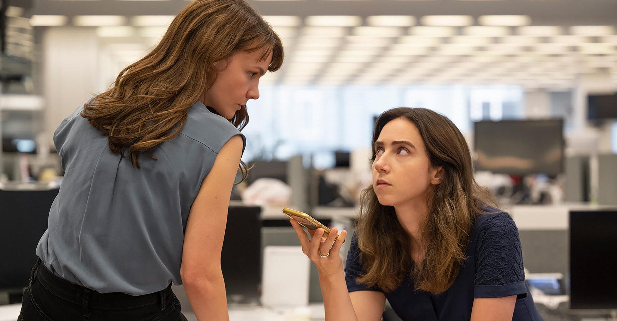 Carey Mulligan and Zoe Kazan as Meghan Twoey and Jodi Kantor taking a phone call with a source in the offices of the New York Times