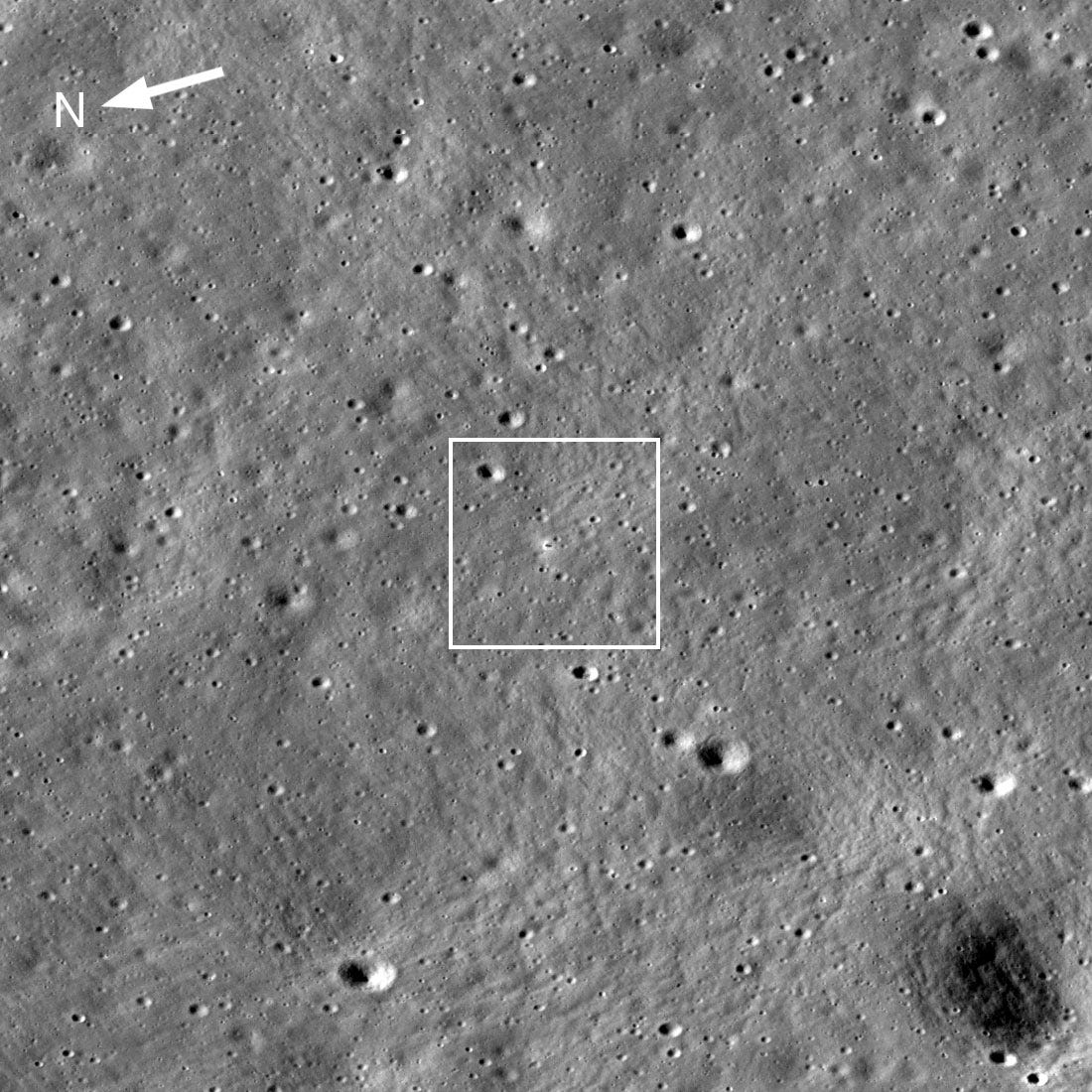 Image of the Moon’s surface saturated in craters, with a tiny black line of the lander’s shadow cast to the right. It’s surrounded by a very small bright white crescent. Image of the Moon’s surface saturated in craters, with a tiny black line of the lander’s shadow cast to the right. It’s surrounded by a very small bright white crescent.