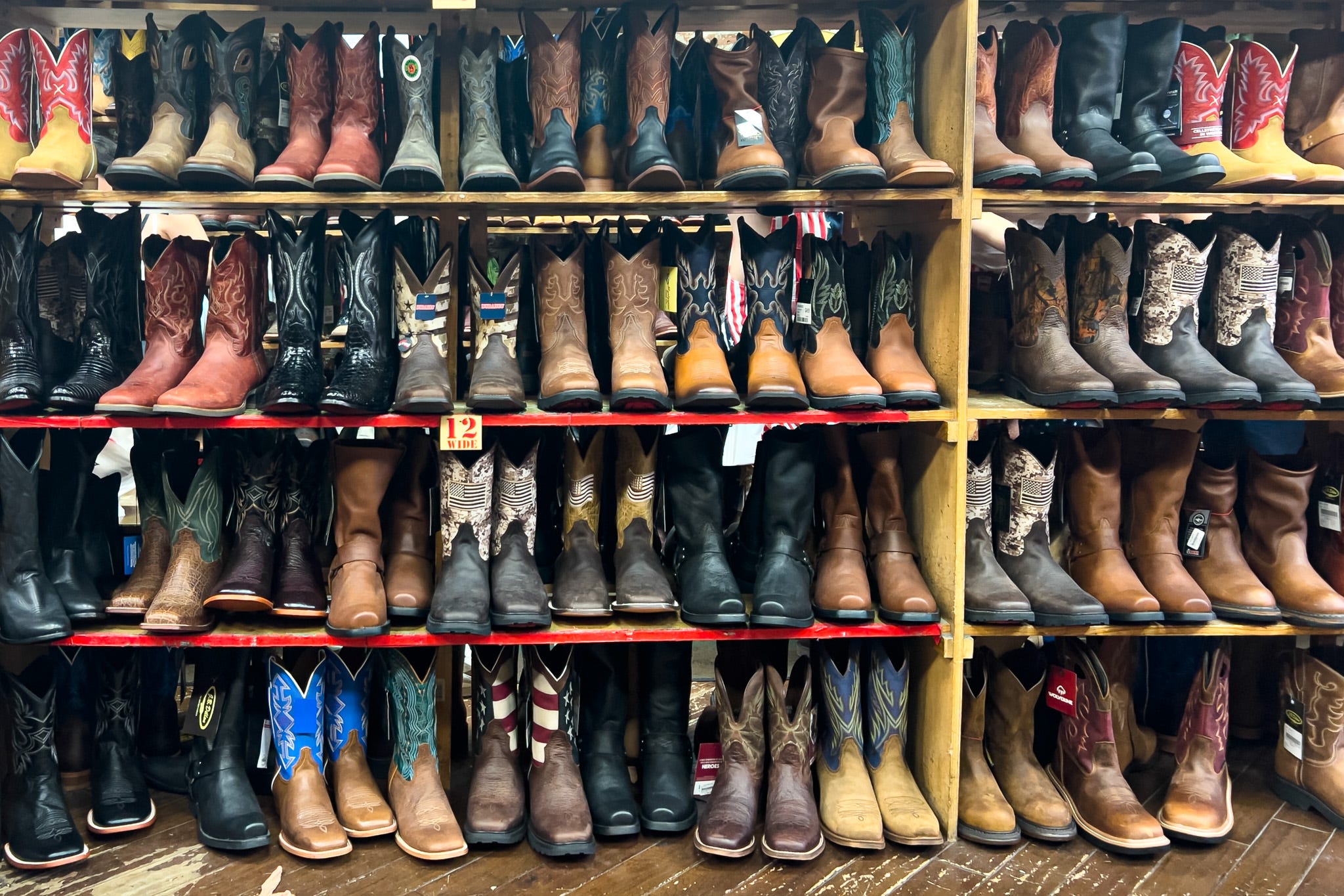 Four rows of cowboy boots on display in a country western boot store