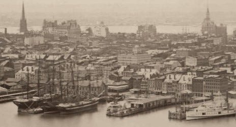 Crowded skyline in which tallest buildings are church steeples, mostly low-rise brick buildings