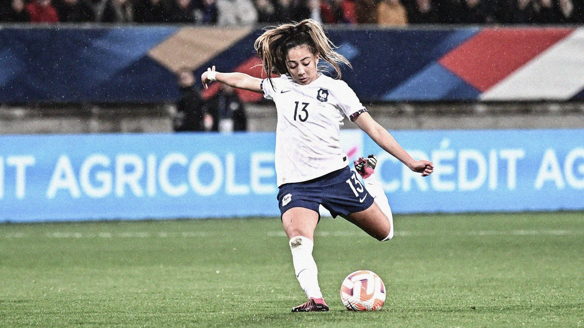 A photo of Selma Bacha in the process of striking the ball with her left foot playing for France
