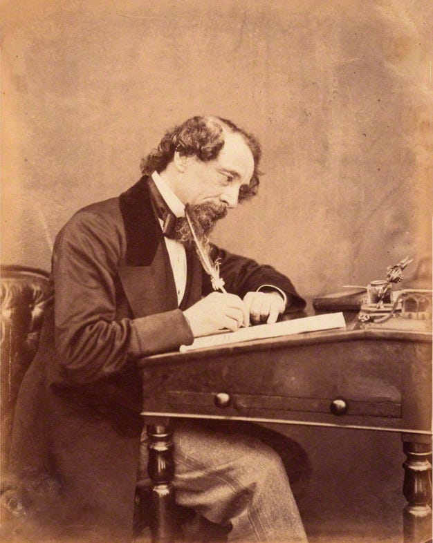 Dickens at his desk, 1858 Public Domain via Wikipedia https://en.wikipedia.org/wiki/Charles_Dickens#/media/File:Dickens_by_Watkins_1858.png